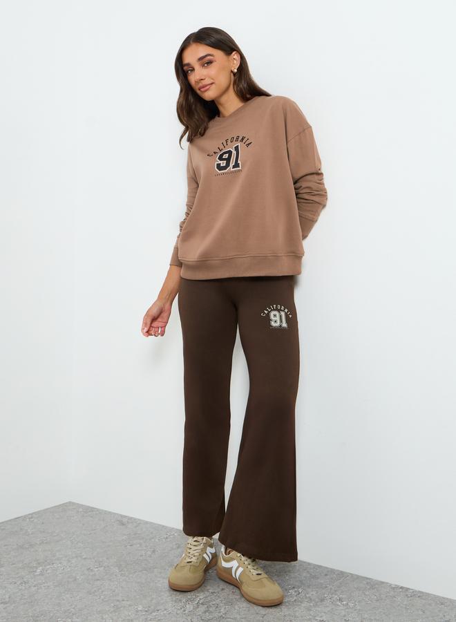 ستايلي طقم منسق من بنطال بأرجل واسعة وسويت شيرت بطبعة كتابة - Image 1